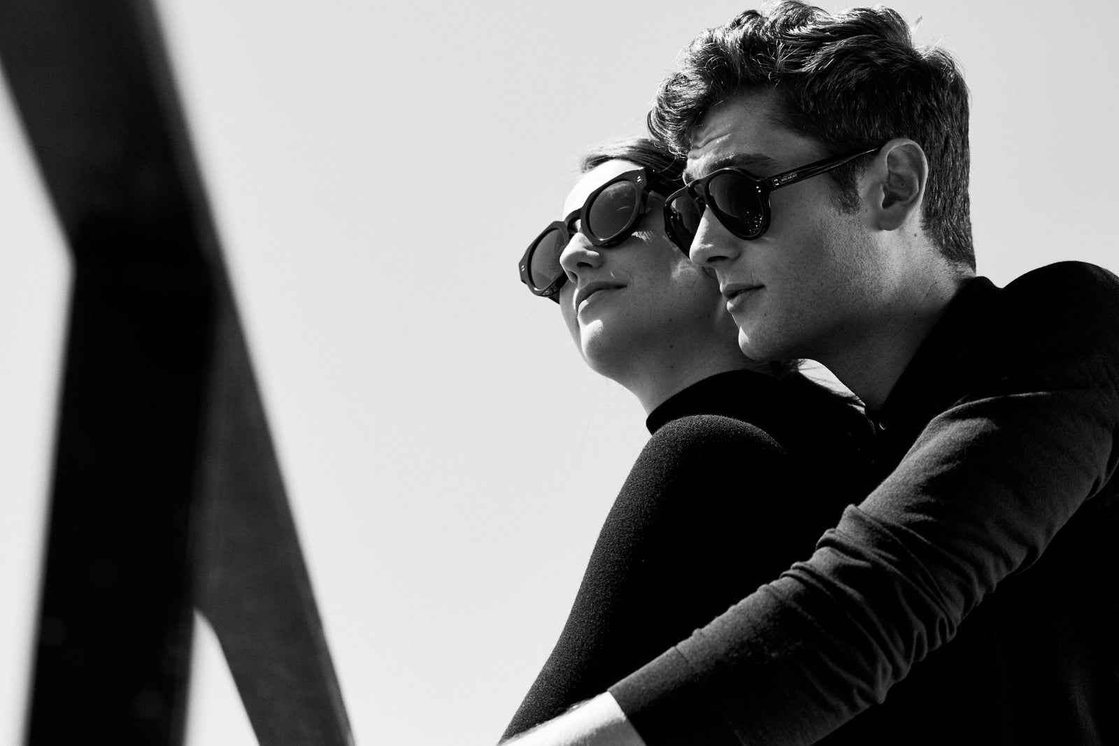 A couple in sunglasses against a bright sky