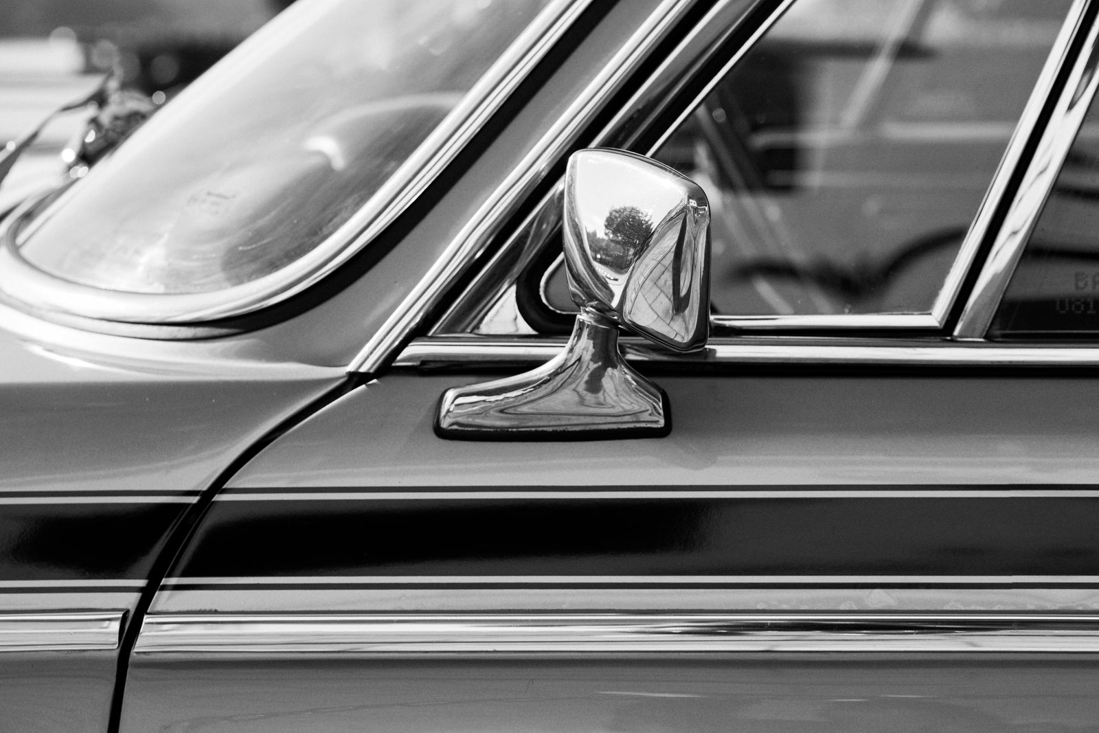 The chrome wing mirror of a vintage car