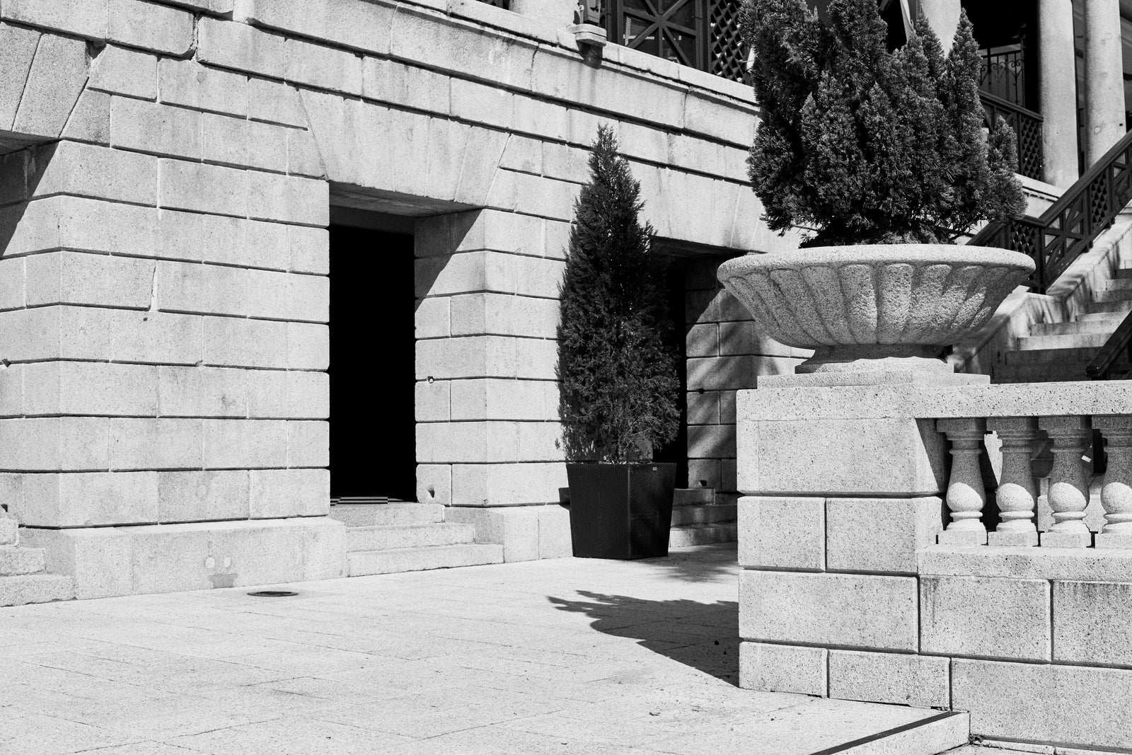A stone façade with a cypress and a stone urn