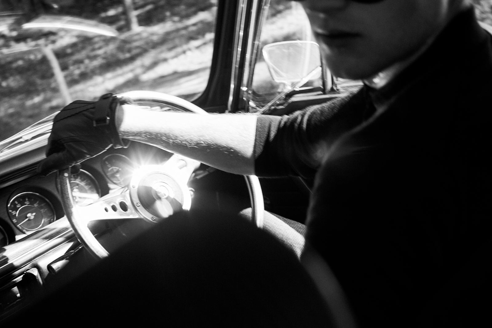 A gloved hand on a wooden steering wheel