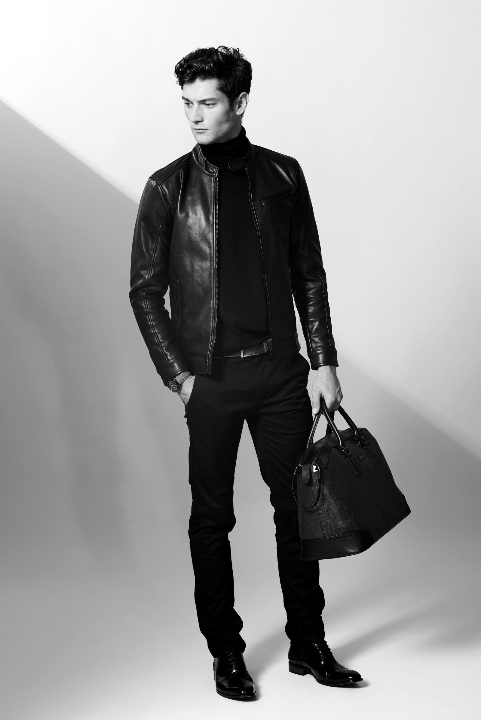 A man in a leather jacket carrying a bag